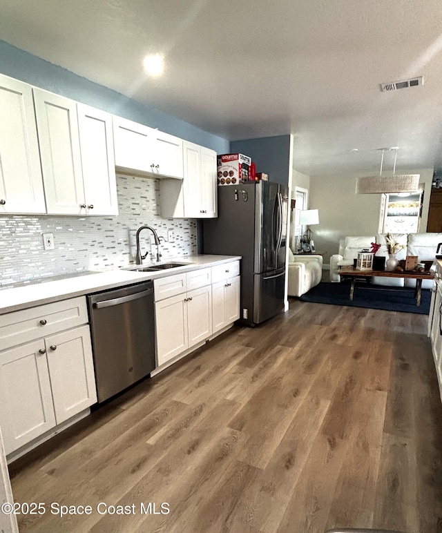 kitchen featuring dark wood-type flooring, sink, white cabinets, and stainless steel appliances