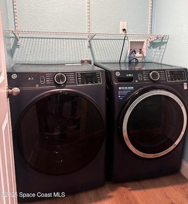 laundry room with washer and clothes dryer and hardwood / wood-style floors