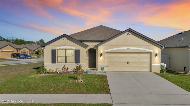 ranch-style home featuring a yard and a garage