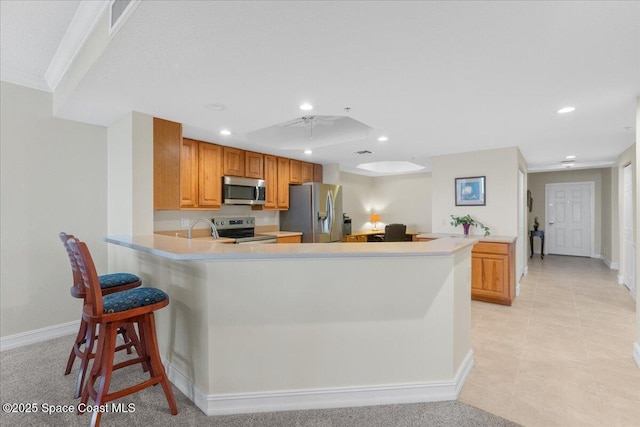 kitchen with stainless steel appliances, crown molding, a breakfast bar, and kitchen peninsula