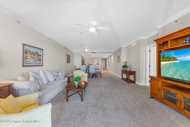 living room with ceiling fan, ornamental molding, and light carpet