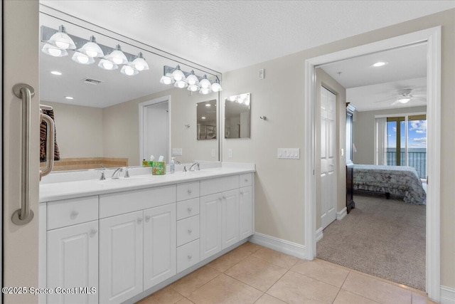 bathroom featuring vanity, ceiling fan, tile patterned floors, and a textured ceiling