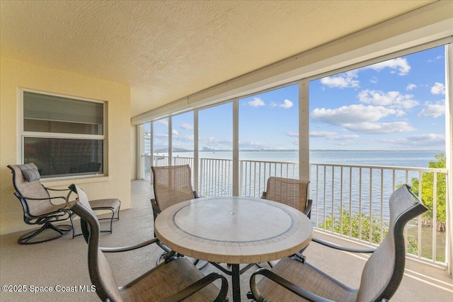 sunroom / solarium featuring a wealth of natural light and a water view