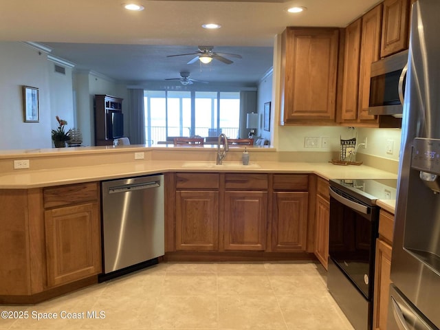 kitchen featuring stainless steel appliances, crown molding, sink, and kitchen peninsula