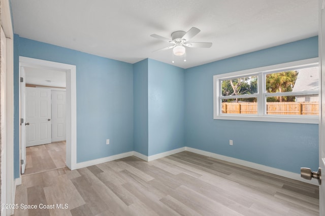 empty room featuring ceiling fan and light hardwood / wood-style floors