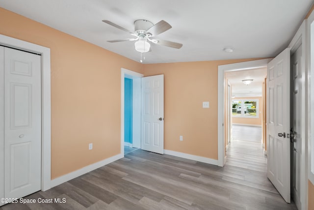 unfurnished bedroom with light wood-type flooring, a closet, vaulted ceiling, and ceiling fan