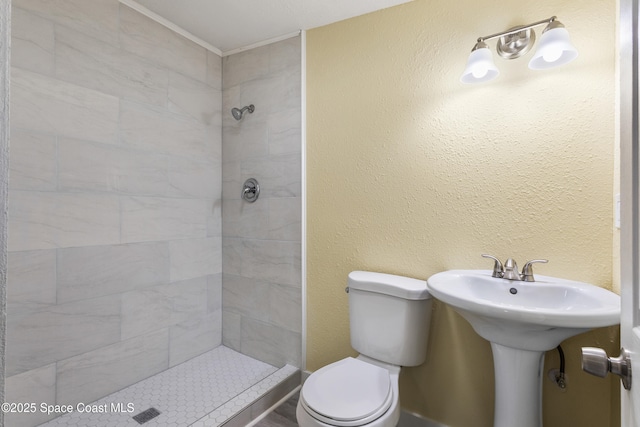 bathroom featuring toilet and tiled shower