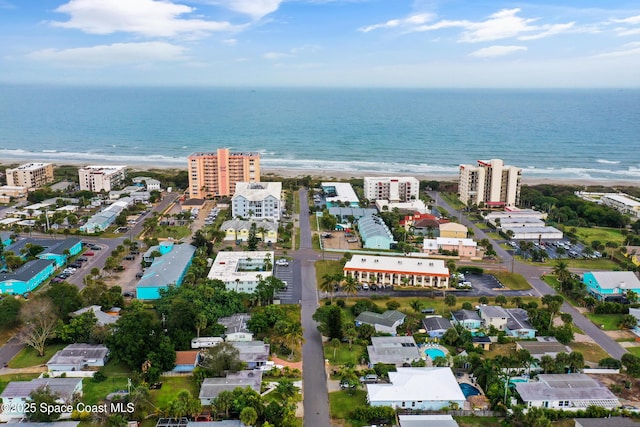 birds eye view of property with a water view and a beach view