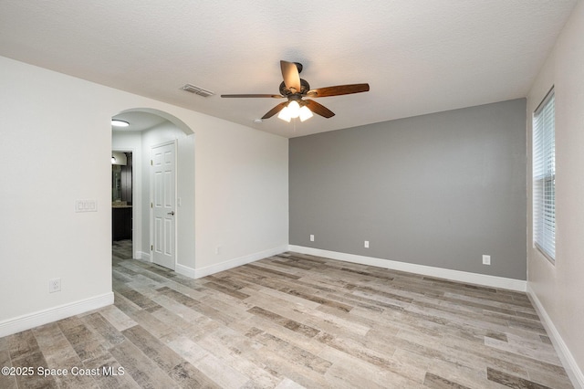 spare room with a textured ceiling, light hardwood / wood-style flooring, and ceiling fan