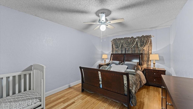 bedroom with ceiling fan, a textured ceiling, and light wood-type flooring