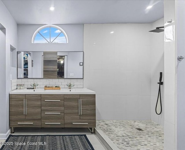 bathroom with a shower, decorative backsplash, tile patterned floors, and vanity