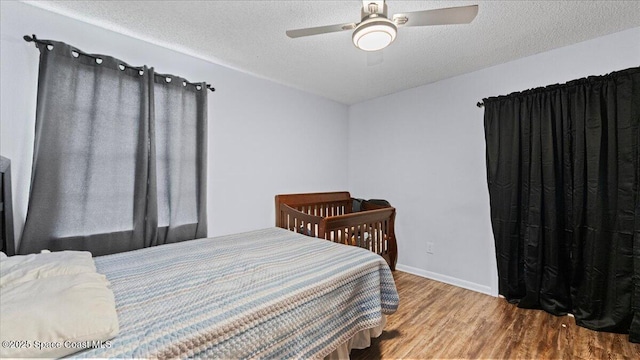 bedroom featuring hardwood / wood-style floors, a textured ceiling, and ceiling fan