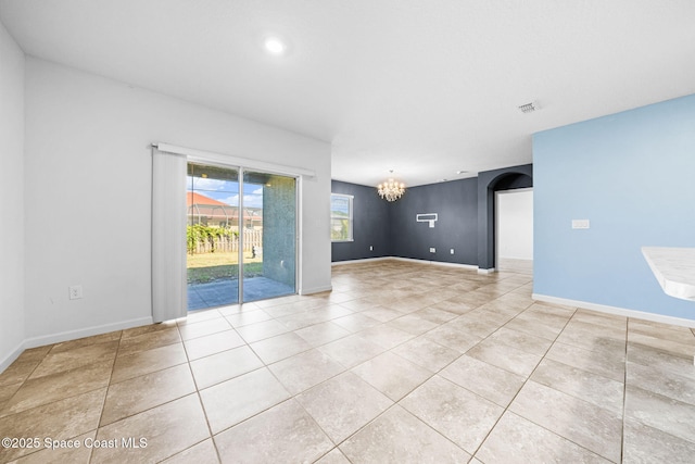 empty room featuring light tile patterned floors and a notable chandelier