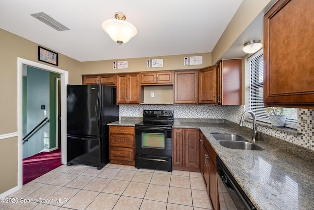 kitchen with light tile patterned floors, black appliances, backsplash, dark stone counters, and sink