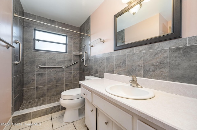 bathroom featuring toilet, tiled shower, tile walls, tile patterned floors, and vanity