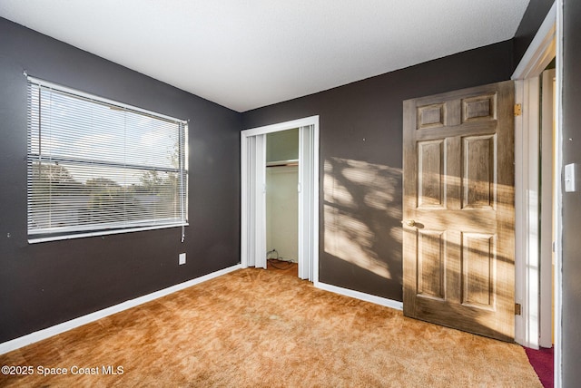 unfurnished bedroom featuring a closet and light colored carpet