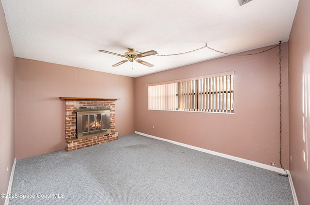 unfurnished living room featuring a brick fireplace, carpet floors, and ceiling fan