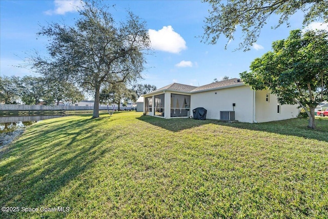 view of yard with a sunroom, a water view, and central AC unit