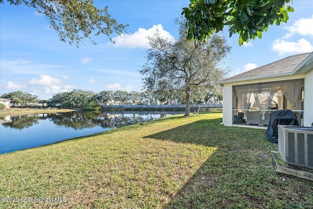 view of yard with a water view and central AC