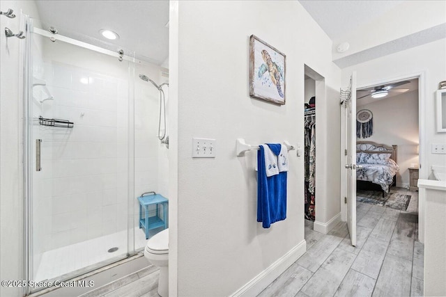 bathroom with toilet, an enclosed shower, and ceiling fan