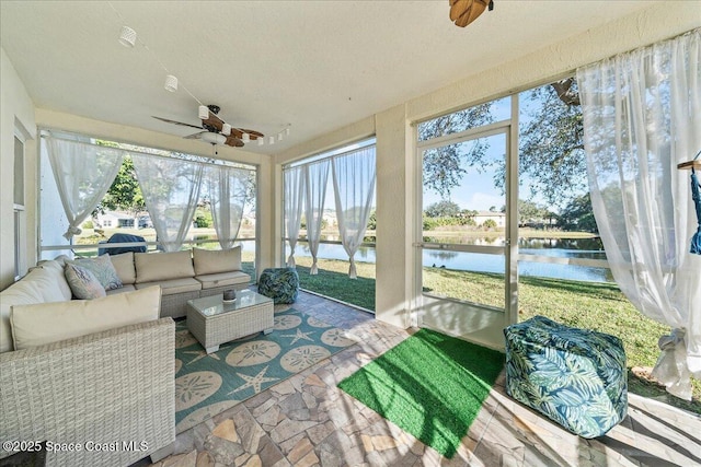 sunroom / solarium featuring a water view and ceiling fan