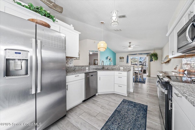 kitchen with white cabinetry, ceiling fan, kitchen peninsula, decorative light fixtures, and appliances with stainless steel finishes