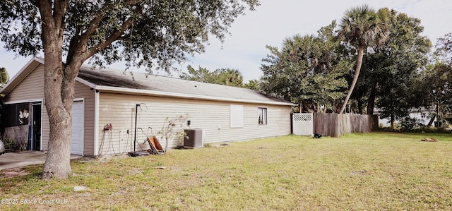 view of side of property featuring a lawn and central air condition unit