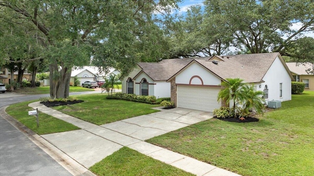 view of front facade featuring a front yard, a garage, and central air condition unit