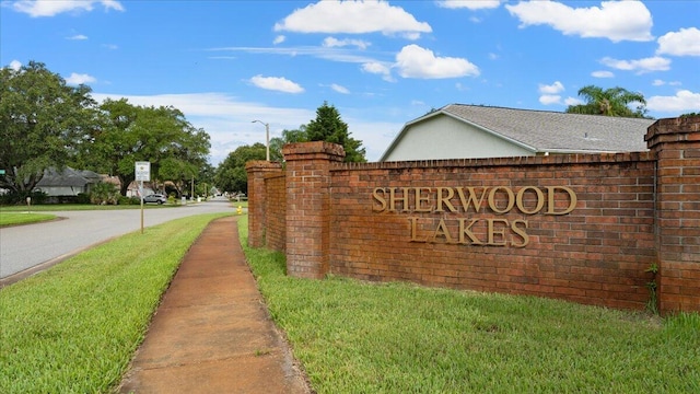 community / neighborhood sign featuring a yard