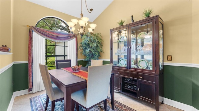 tiled dining space with vaulted ceiling and a notable chandelier