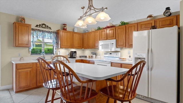 kitchen featuring hanging light fixtures, a chandelier, a textured ceiling, white appliances, and light tile patterned floors