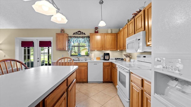 kitchen featuring french doors, sink, pendant lighting, white appliances, and light tile patterned floors