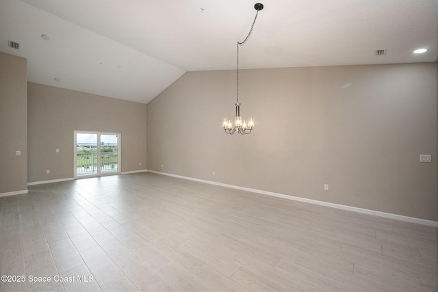 empty room with a notable chandelier, light wood-type flooring, and lofted ceiling