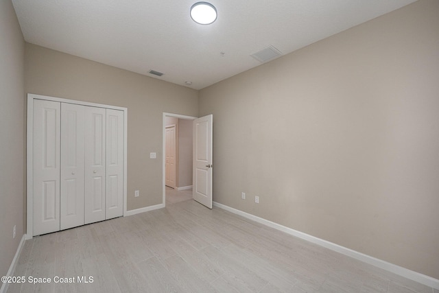 unfurnished bedroom with a closet and light hardwood / wood-style flooring