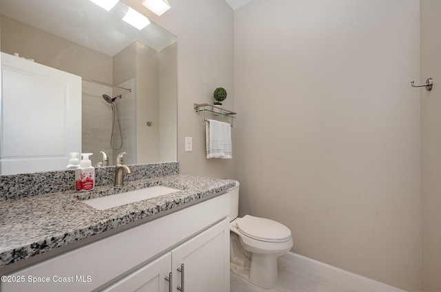 bathroom featuring a tile shower, tile patterned flooring, vanity, and toilet