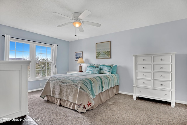 carpeted bedroom featuring ceiling fan and a textured ceiling