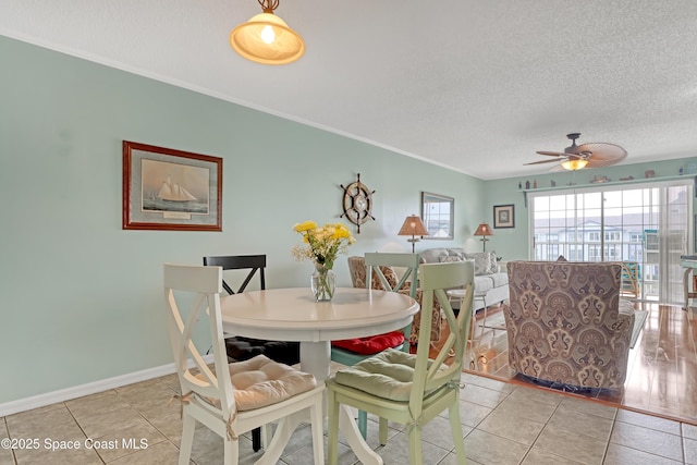 tiled dining room featuring a textured ceiling, ceiling fan, and ornamental molding