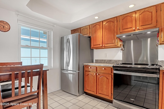 kitchen featuring a tray ceiling, light tile patterned floors, and appliances with stainless steel finishes