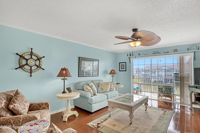 living room featuring ceiling fan, dark hardwood / wood-style floors, and a textured ceiling