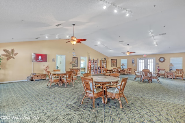 dining space with a textured ceiling, ceiling fan, french doors, and lofted ceiling