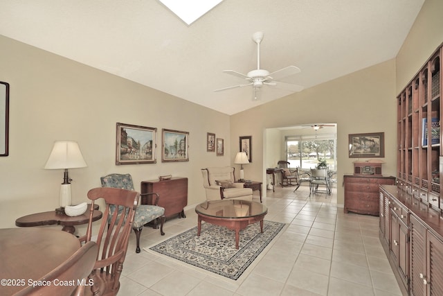 living room featuring ceiling fan, light tile patterned floors, and lofted ceiling