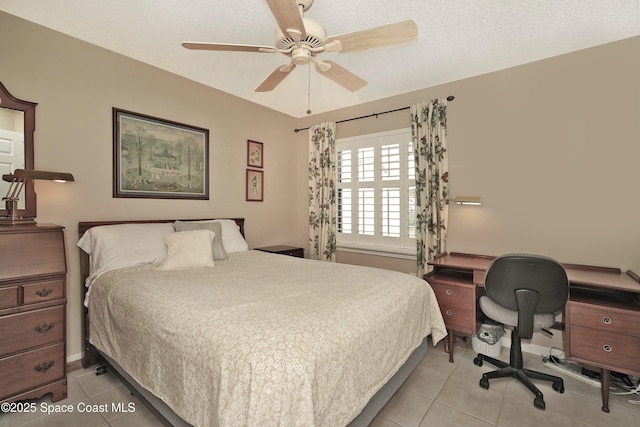 bedroom with ceiling fan, light tile patterned flooring, and a textured ceiling