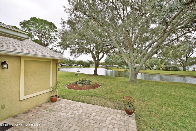 view of yard with a water view and a patio