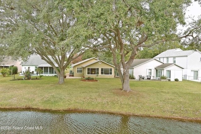 view of front of home with a water view and a front lawn