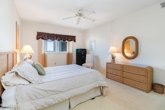 bedroom featuring visible vents, a ceiling fan, and light colored carpet