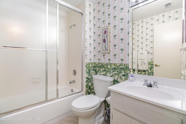 full bathroom with bath / shower combo with glass door, visible vents, toilet, vanity, and wallpapered walls