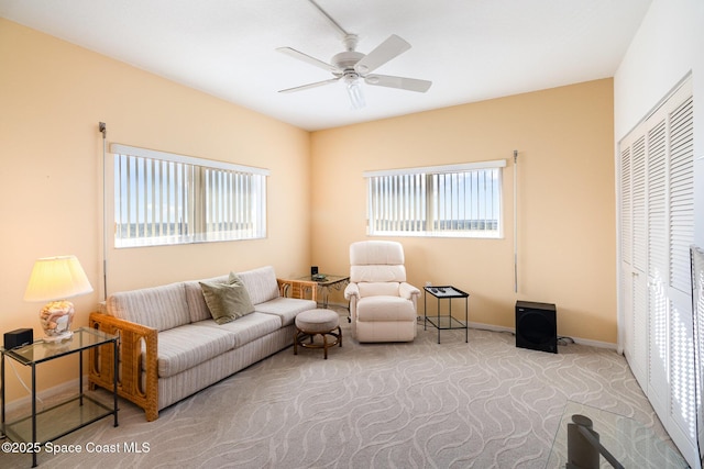 living room with light carpet, ceiling fan, and baseboards