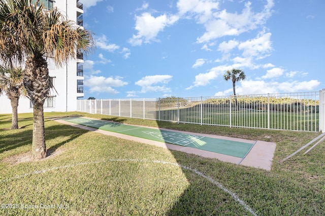 view of home's community featuring fence, shuffleboard, and a yard