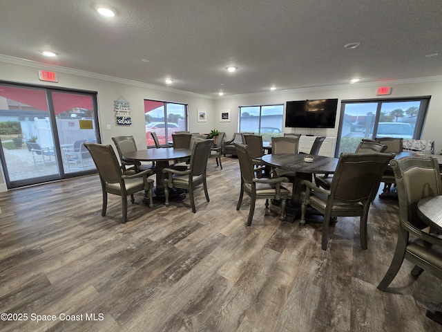 dining space with a textured ceiling, recessed lighting, wood finished floors, and crown molding