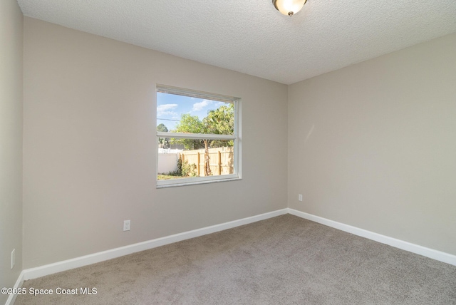 carpeted spare room featuring a textured ceiling